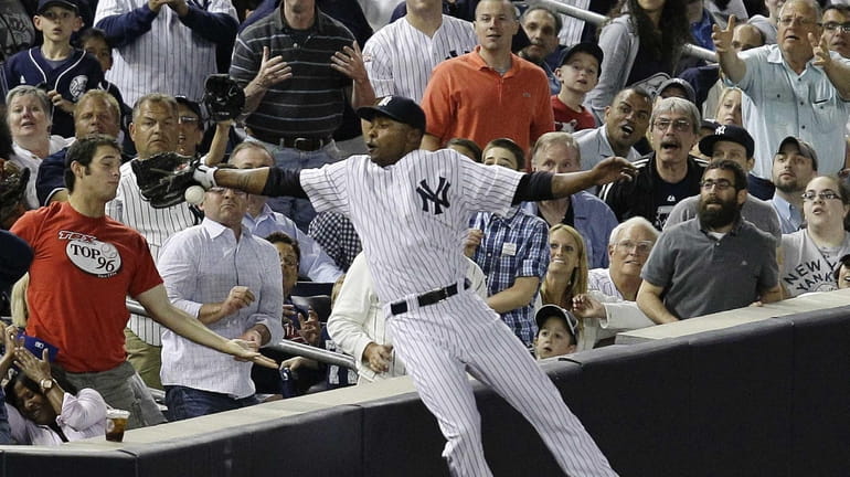 Fans watch as New York Yankees left fielder Dewayne Wise...