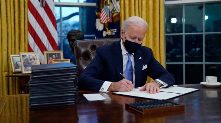 President Joe Biden signs his first executive orders in the...