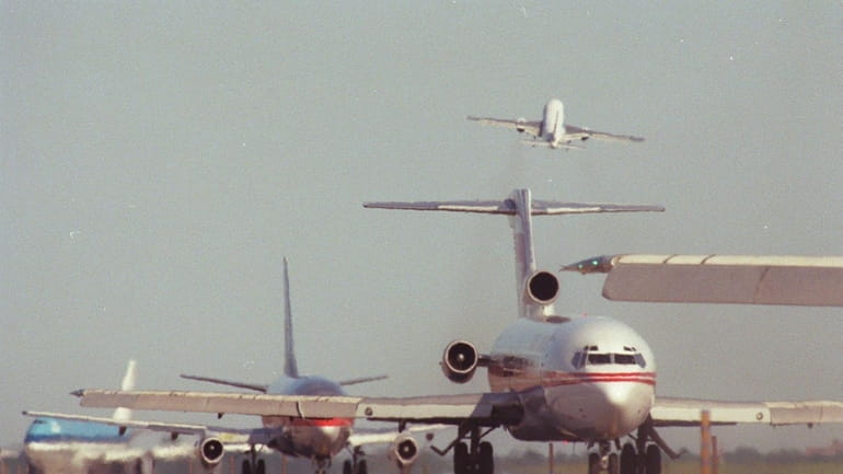 Commercial planes on a congested runway at JFK Airport, waiting...