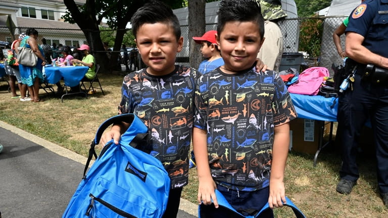 From left, twins Jayden and James Hernandez of Westbury show off their...