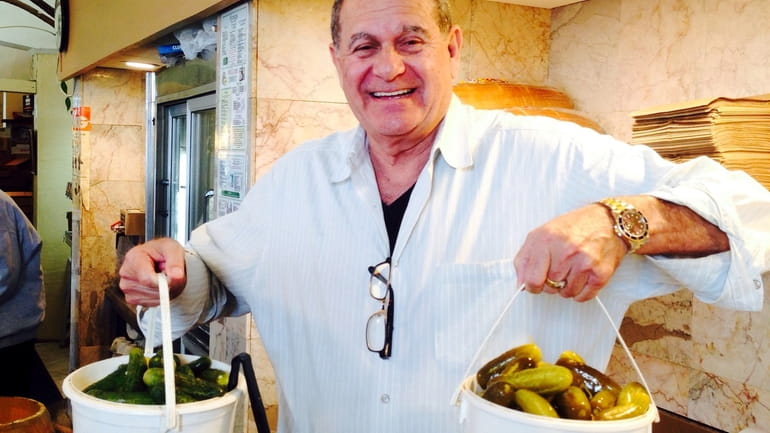 Steven Weiss holds pails of pickles at Regal Kosher Delicatessen...