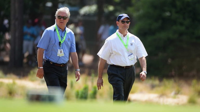 USGA President, Thomas O'Toole, Jr. (L) walks with Mike Davis...