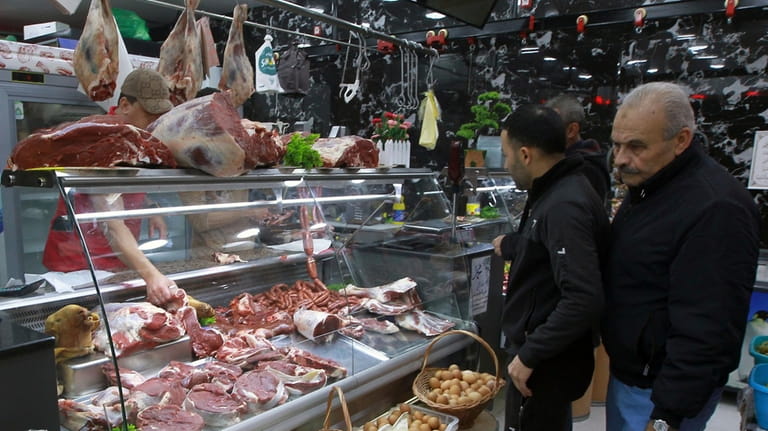 People shop for beef in a butchery in Algiers, Algeria,...
