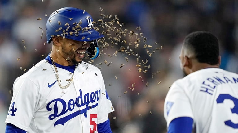 Los Angeles Dodgers' Mookie Betts, left, is hit with sunflower...