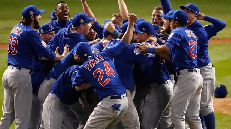 The Chicago Cubs celebrate after defeating the Cleveland Indians 8-7...