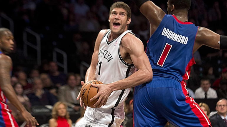 Brook Lopez drives past the Detroit Pistons' Andre Drummond for...
