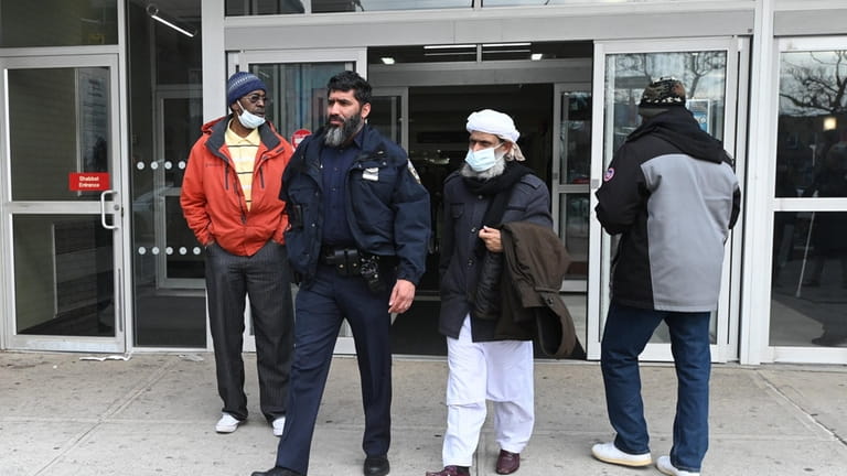 An NYPD officer and Imam walk out of the hospital in Brooklyn...
