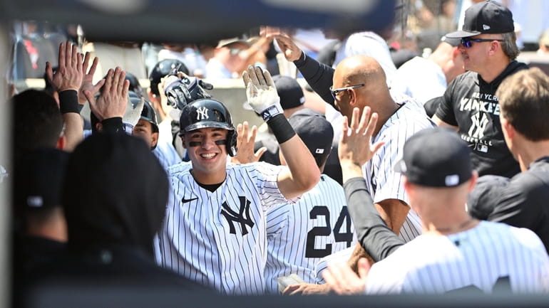 New York Yankees' Anthony Volpe is greeted in the dugout...