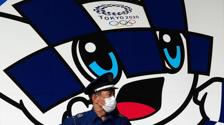 A security guard wearing a mask to help protect against...