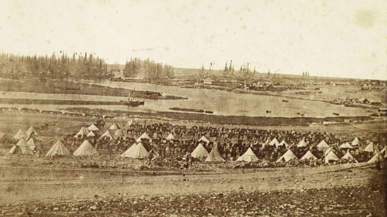 An archival photo of ships and tents at the Port...
