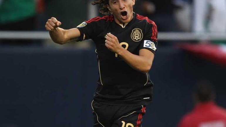 Andres Guardado of Mexico leaps in the air in celebration...