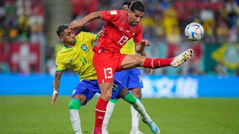 Switzerland's Ricardo Rodriguez, right, vies for the ball with Brazil's...