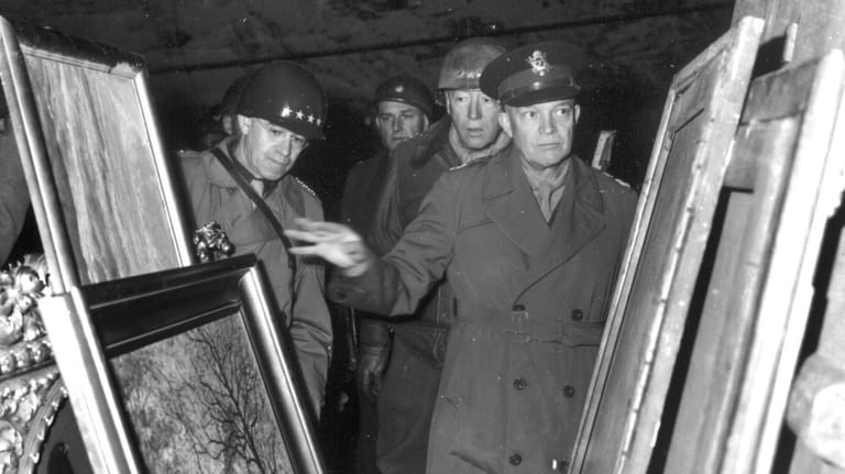 Gen. Dwight D. Eisenhower, center, inspects paintings in a salt...