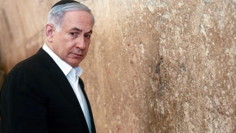 Israeli Prime Minister Benjamin Netanyahu looks on before praying at...