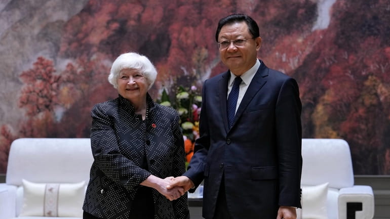 U.S. Treasury Secretary Janet Yellen, left, shakes hands with Wang...
