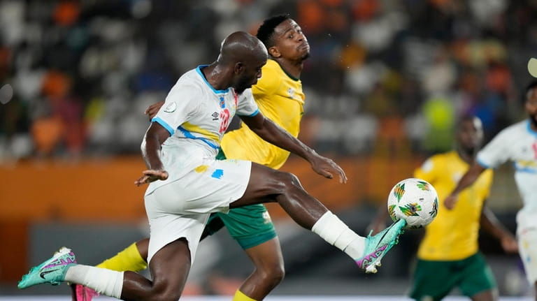 DR Congo's Yoane Wissa, left, kicks the ball as he...
