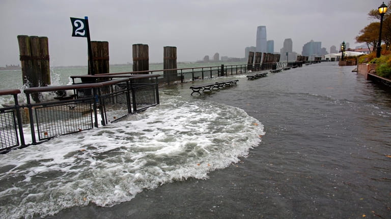 FILE — Waves wash over the seawall near high tide...
