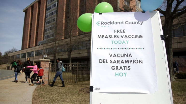 A sign advertising free measles vaccines is displayed at the...