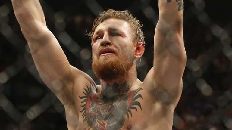 Conor McGregor celebrates after defeating Chad Mendes in their interim...
