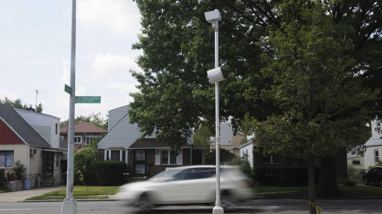 A speed camera clocks vehicles traveling southbound on Utopia Parkway...
