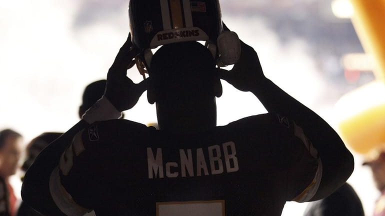 Washington Redskins quarterback Donovan McNabb pulls his helmet on in...