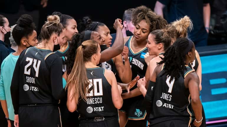 The Liberty celebrate their win after an WNBA game against...