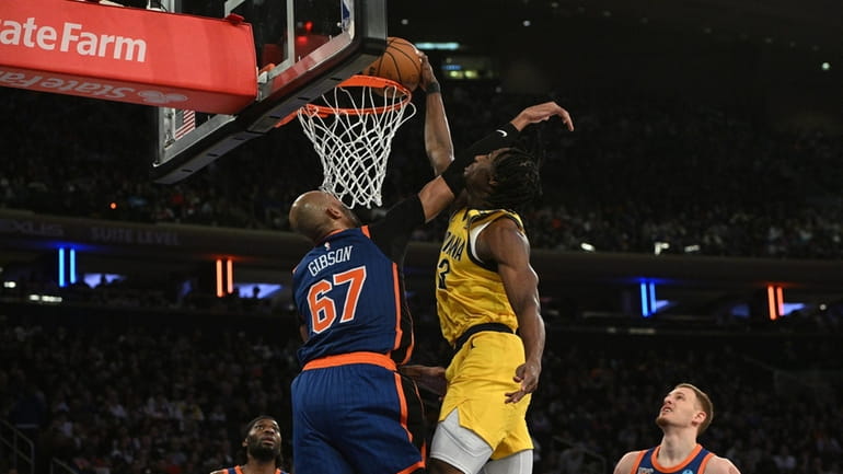 Indiana Pacers forward Aaron Nesmith dunks past Knicks forward Taj Gibson...