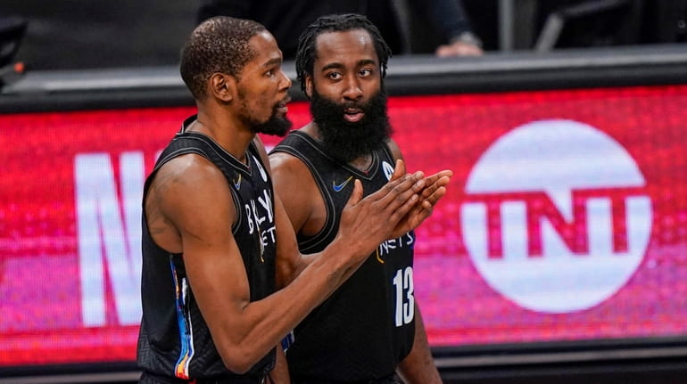 Nets forward Kevin Durant and guard James Harden look on in...