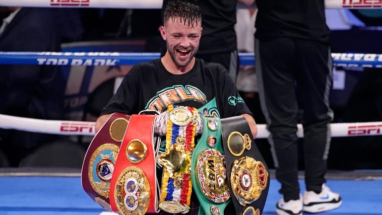 Josh Taylor celebrates while holding his belts after defeating Jose...