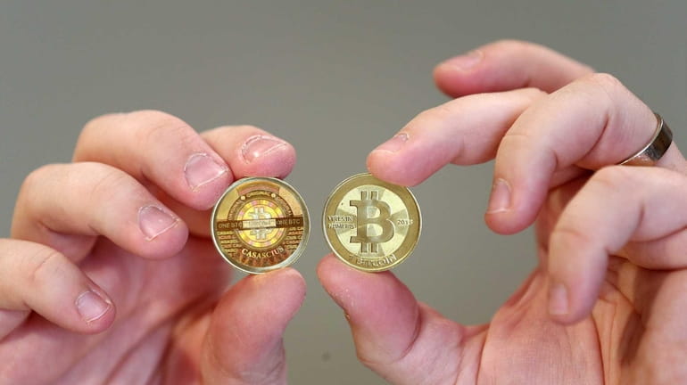 Souvenir coins hold the logo of Bitcoin, a virtual currency...
