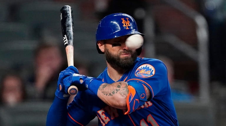 Mets' Kevin Pillar is hit in the face with a...