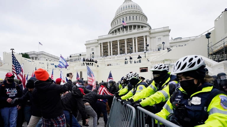 Trump supporters try to break through a police barrier, Wednesday,...