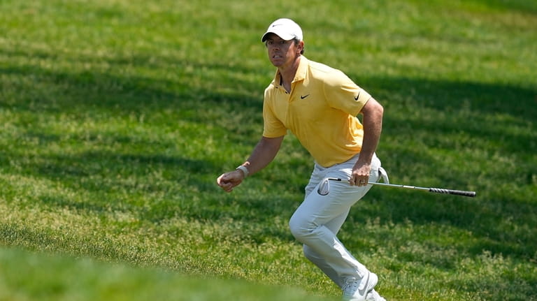 Rory McIlroy, of Northern Ireland, runs up a hill to...