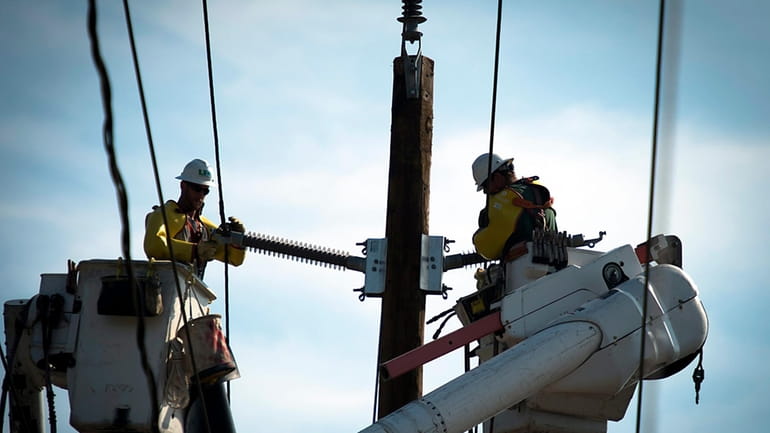 LIPA workers repair power lines after an accident in Elmont...
