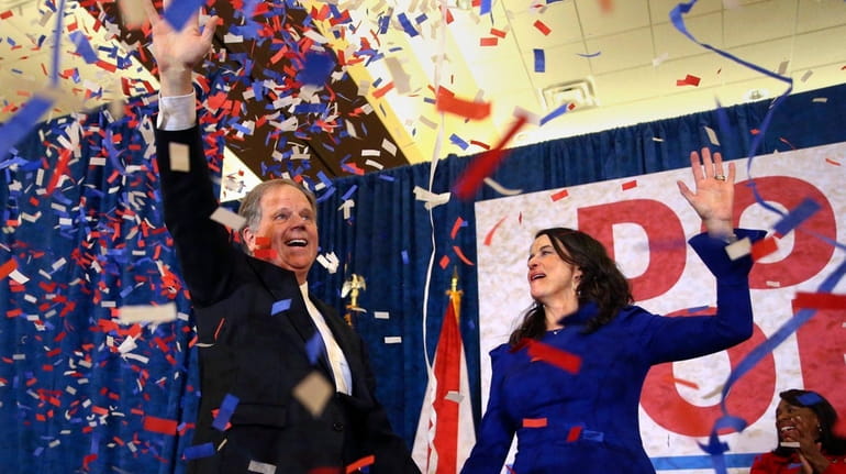 Democrat Doug Jones and his wife, Louise, wave to supporters...