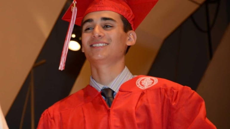 Justin Benigno, 17, of Massapequa, accepts his diploma at the...