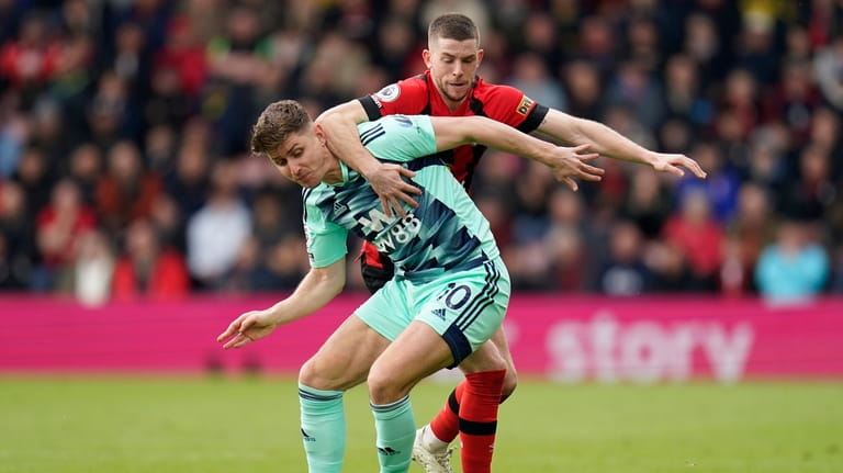 Fulham's Tom Cairney, left, and Bournemouth's Ryan Christie battle for...