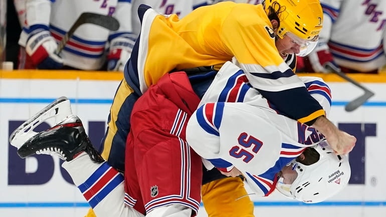 The Predators' Jeremy Lauzon and the Rangers' Ryan Lindgren fight in the second...