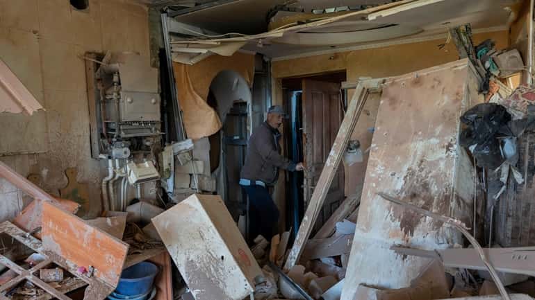 Resident Alexander, 67, checks the flat of his neighbor destroyed...