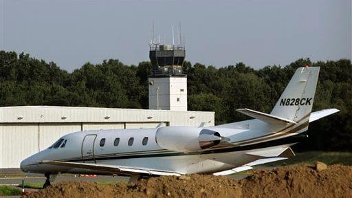 A plane taxis past a control tower at Teterboro Airport.