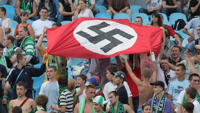 Soccer fans show a German Nazi flag with a swastika...