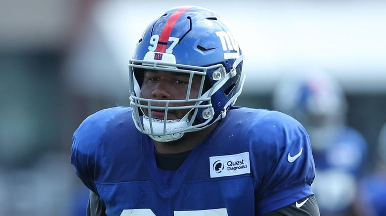 Giants defensive tackle Dexter Lawrence runs a defensive drill during training...