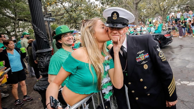Kelsey Goran of Kennesaw, Ga., left, kisses a sailor from...