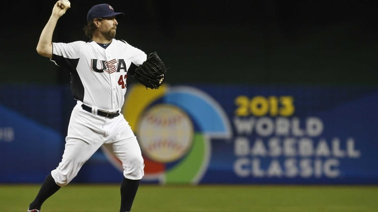 United States' R.A. Dickey attempts a pickoff throw in the...