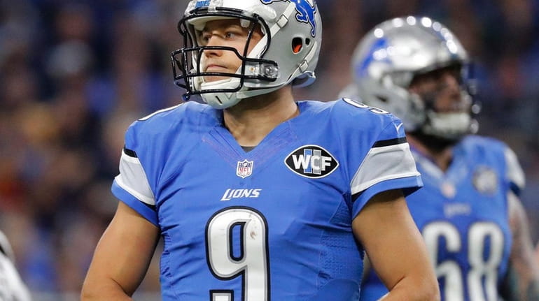 Lions quarterback Matthew Stafford holds his injured finger in the...