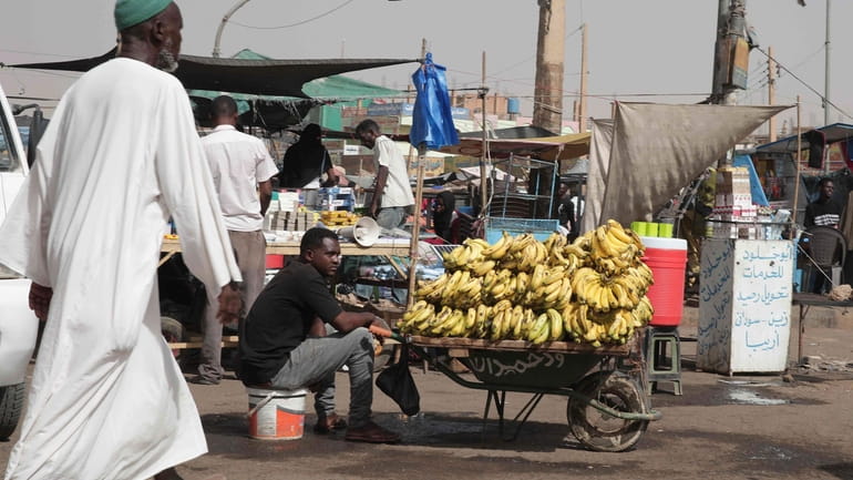 A man sells bananas at a market during a cease-fire...