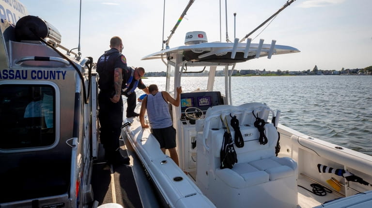 Nassau County Marine Bureau officers inspect a boat while on patrol...