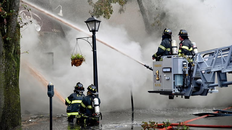 Firefighters battle blaze on Convert Avenue in Floral Park Sunday...