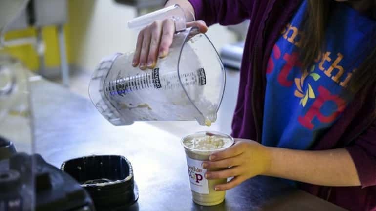 Elizabeth Long, a Smoothie Stop employee, pours a smoothie at...