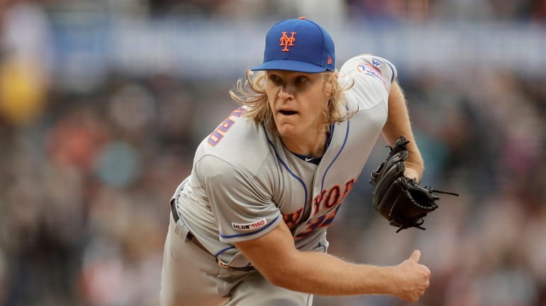 Mets pitcher Noah Syndergaard works against the Giants in the first...